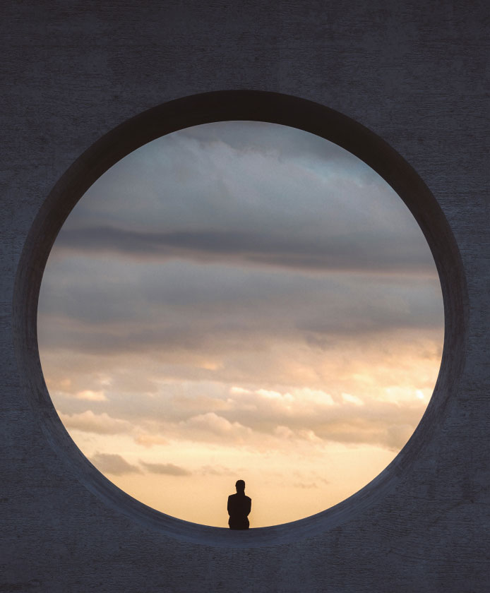 A silhouette of a person looking out at clouds in a circle cutout of a black square - internal communication jobs.