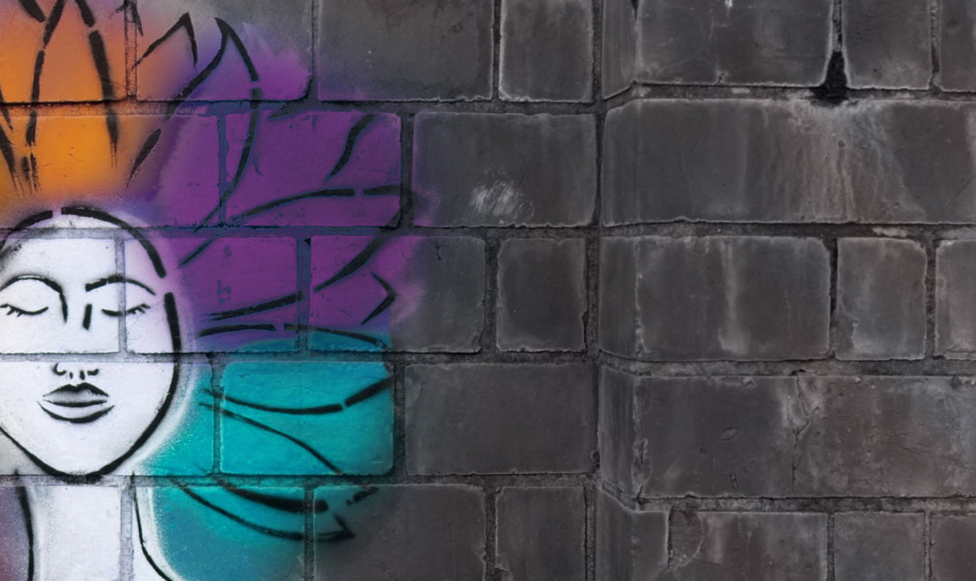 gray brick wall with a spray-painted image of a woman with rainbow hair - internal communications jobs.