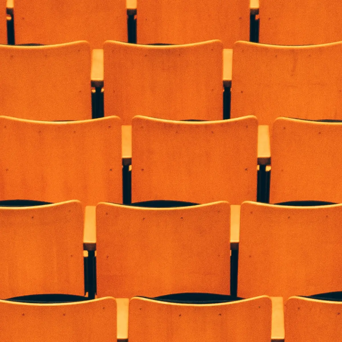 Series of orange chairs lined up in a row to indicate organizational restructuring